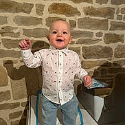 Léo a rejoint le concours — aidez-le/la à gagner de superbes lots ! toddler, child, boy, standing, shirt, jeans, barefoot, indoor, stone_wall, smiling, happy, person, clothing, furniture, cushion, shadow, home, casual, portrait, cute