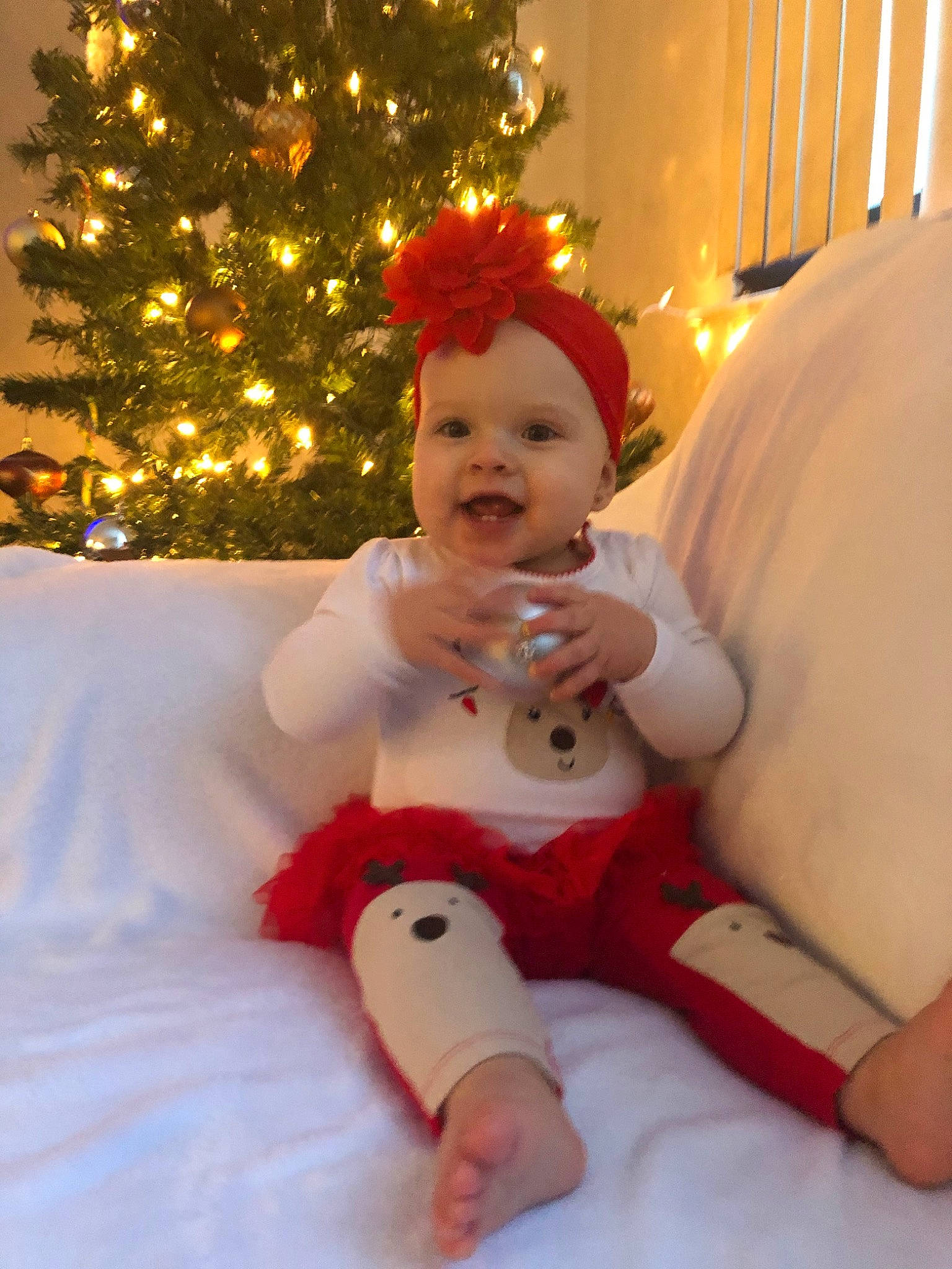 Emmy joined the competition — help win amazing prizes! baby, child, christmas, christmas_decoration, christmas_eve, christmas_lights, christmas_ornament, christmas_tree, event, fictional_character, holiday, person, red, smile, toddler