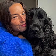 Tiamo a rejoint le concours — aidez-le/la à gagner de superbes lots ! affection, black_dog, blue_sweater, closeup, companion, couch, cozy, cute, dog, friendly, furry, happy, indoor, long_hair, pet, portrait, relaxed, smile, snuggle, woman