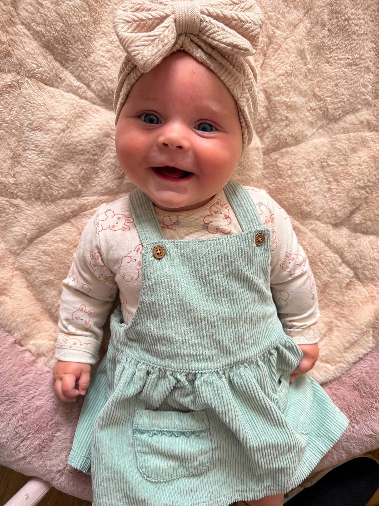 Alexis Page is registered to the contest to win money with this photo: baby, smiling, headband, corduroy_dress, mint_green, blanket, cute, happy, infant, child, clothing, portrait, lying_down, face, blue_eyes, soft_texture, button, pocket, hand, indoor