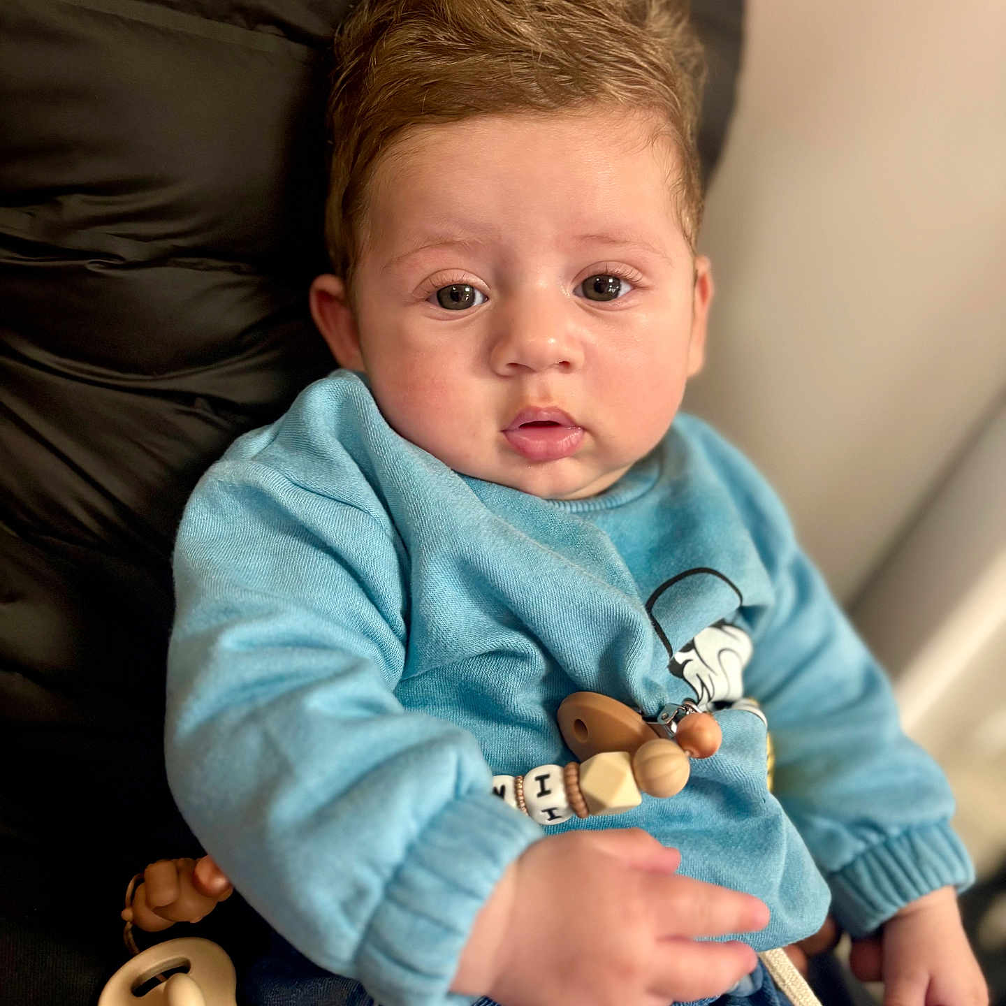 Imrân participe au concours pour gagner de l'argent avec cette photo : baby, child, infant, face, eyes, clothing, blue_sweatshirt, jeans, pacifier, wooden_toy, hand, sitting, indoor, soft_lighting, skin, cute, portrait, young, person, cozy
