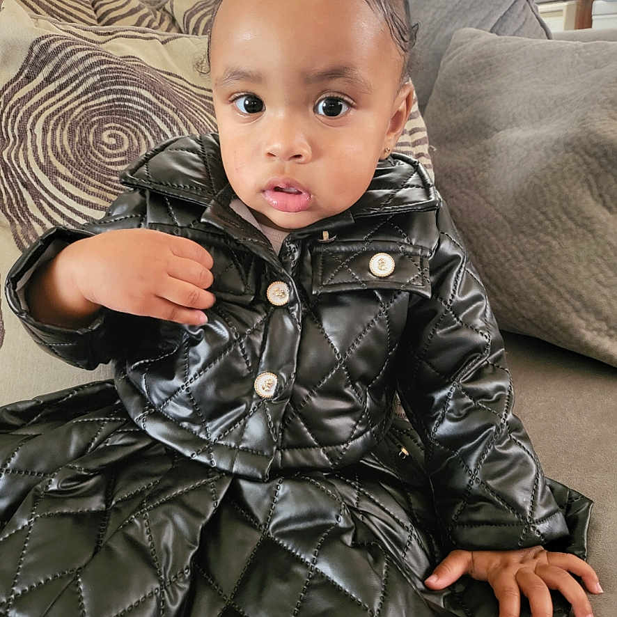 Zalaylah joined the competition — help win amazing prizes! baby, bodypart, clothing, coat, couch, cushion, face, finger, furniture, hand, head, homedecor, hood, jacket, overcoat, pants, person, photography, portrait, sitting