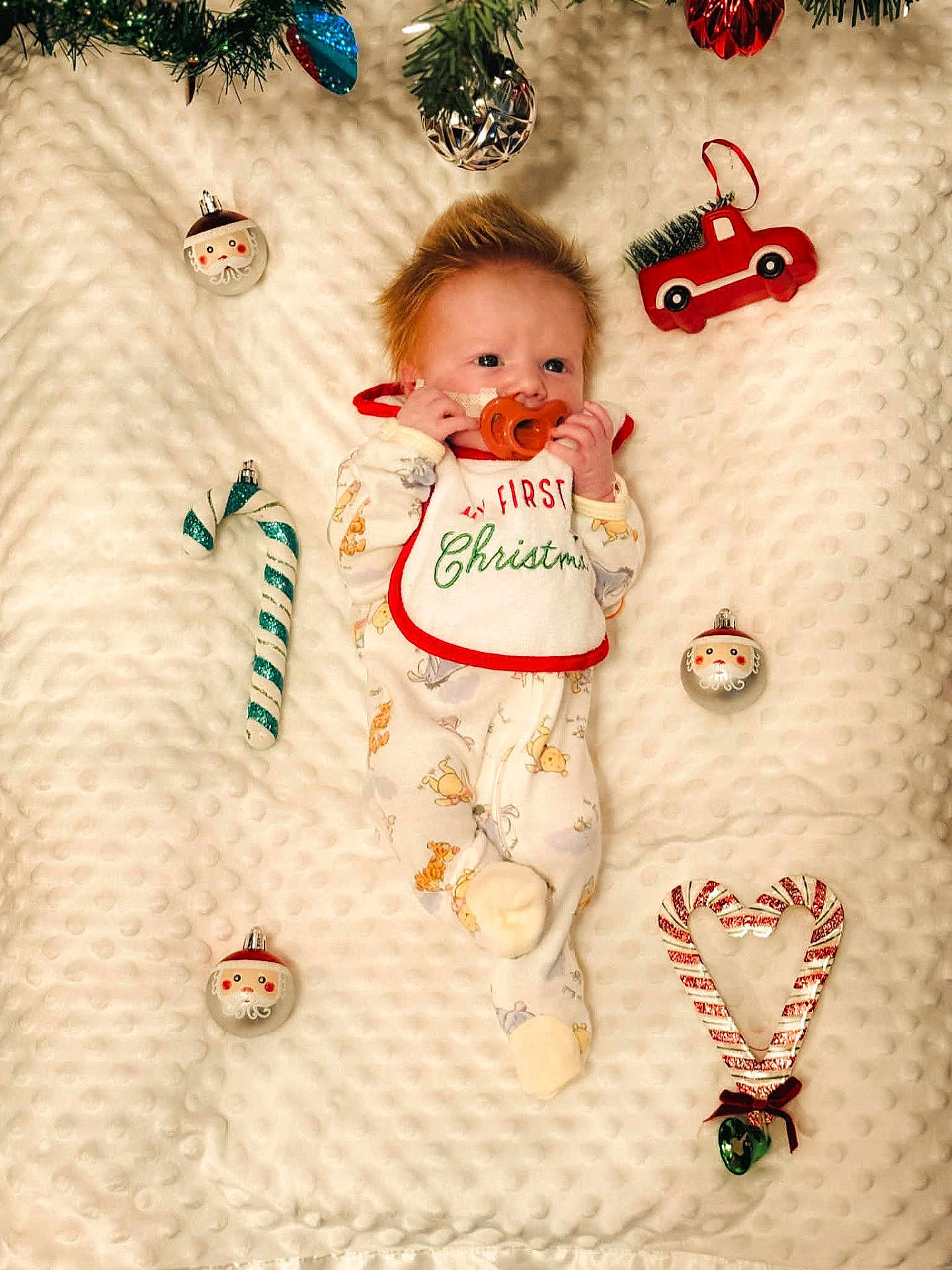 Tyson is registered to the contest to win money with this photo: baby, infant, blanket, christmas, holiday, ornaments, candy_cane, pacifier, bib, toy_truck, santa_ornament, plush, cute, sleepwear, festive, decorations, holiday_season, newborn, soft_texture, lying_down
