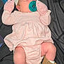 baby, sleeping, pacifier, pink_clothing, mittens, headband, booties, blanket, indoor, infant, cute, resting, newborn, soft_fabric, cozy, person, child, toddler, footwear, bed