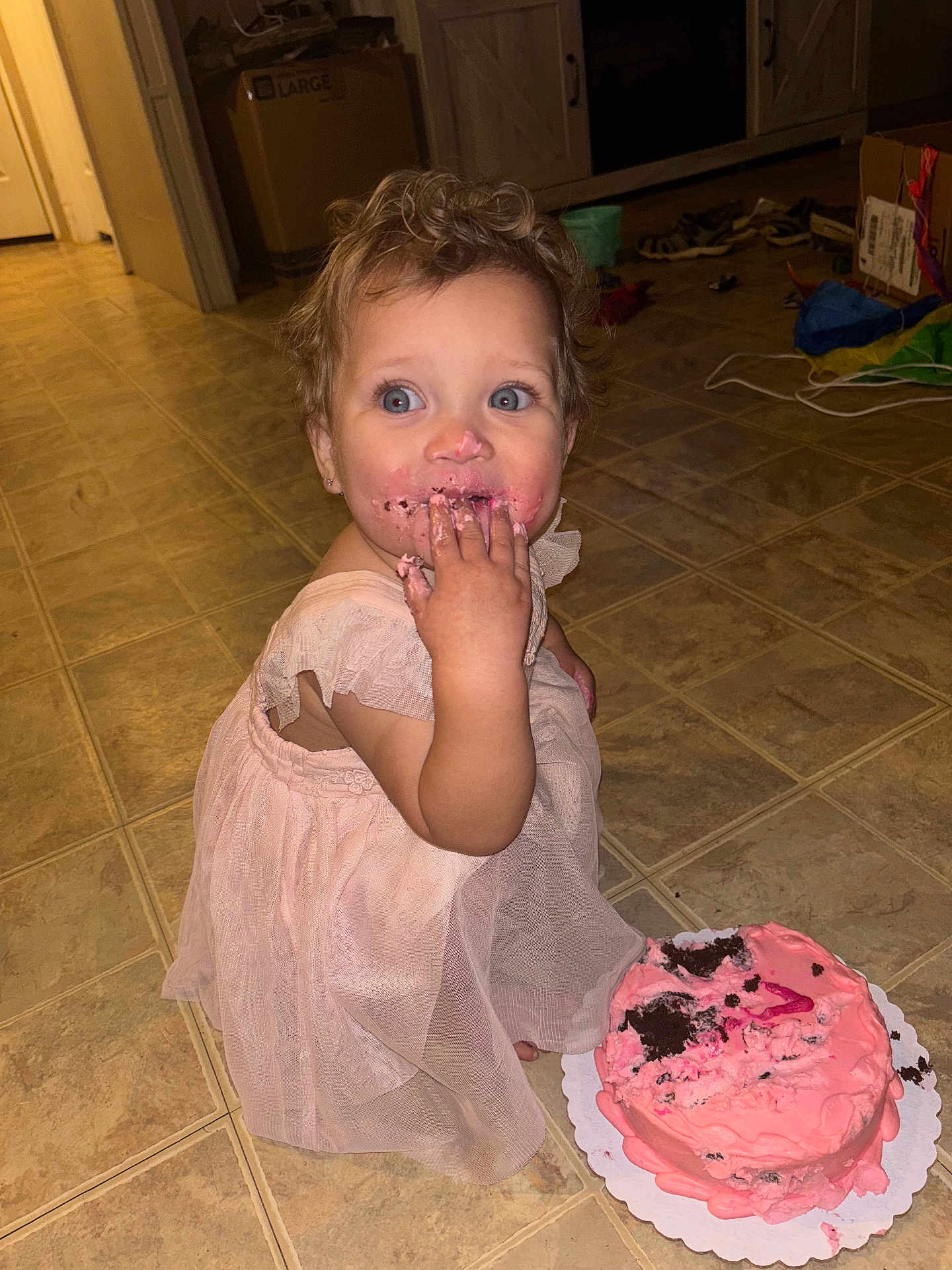 Rosilee joined the competition — help win amazing prizes! blue_eyes, cake, celebration, child, curly_hair, cute, dress, floor, food, fun, happy, home, indoors, messy, person, pink_frosting, playful, portrait, smiling, toddler