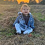 baby, child, denim_jacket, grass, sunset, outdoor, smiling, curly_hair, nature, field, clothing, happy, sitting, person, portrait, casual_wear, blue_eyes, daylight, young_child, scenery