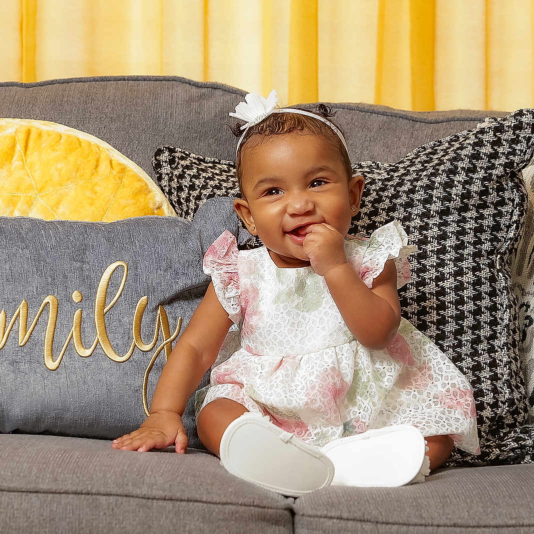 Lilliana is registered to the contest to win money with this photo: architecture, baby, bodypart, building, clothing, couch, cushion, dress, face, furniture, head, homedecor, indoors, livingroom, person, photography, pillow, portrait, room, sitting