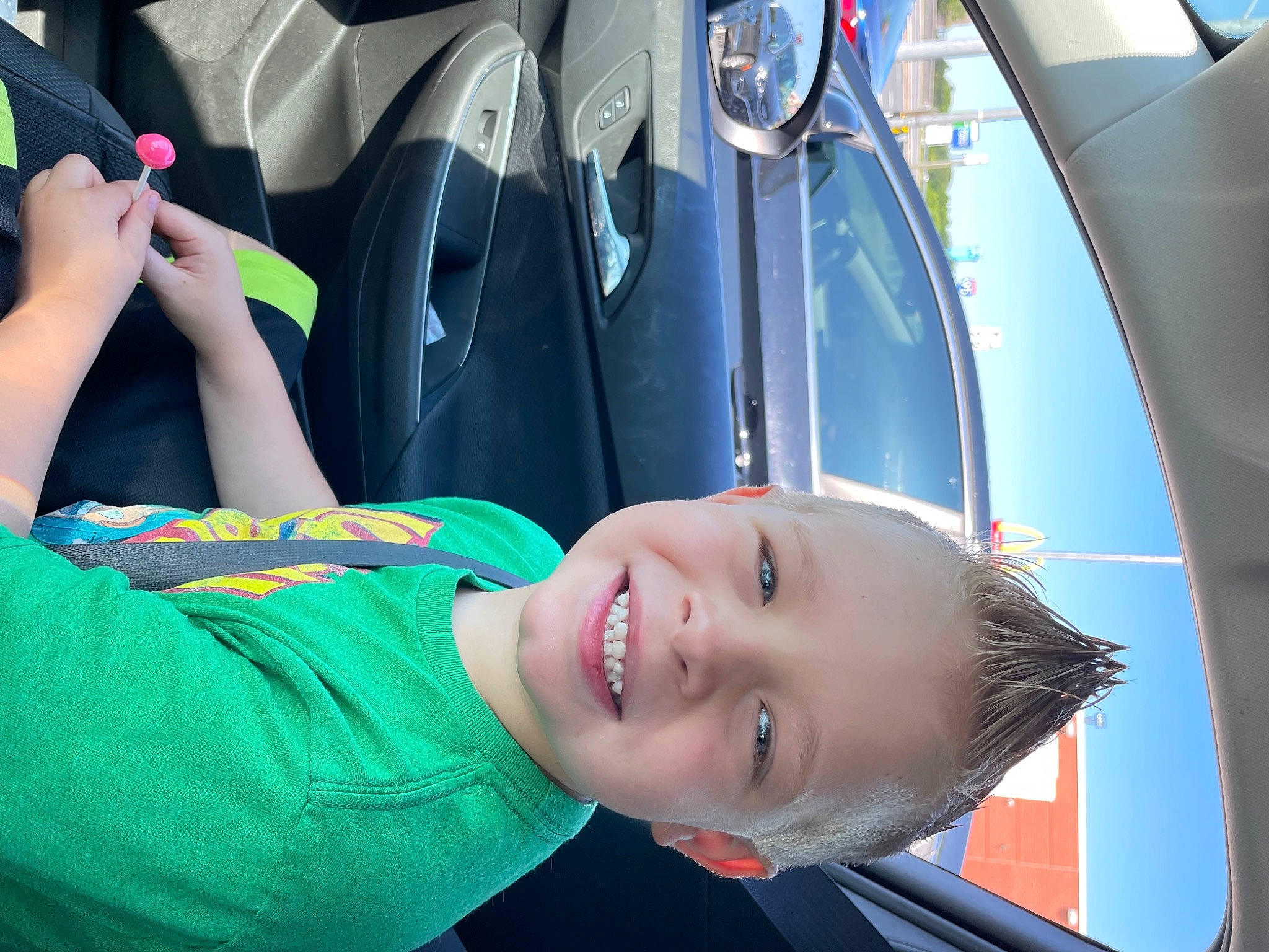 Caleb is registered to the contest to win money with this photo: auto_part, automotive_design, automotive_exterior, automotive_lighting, bumper, car, cool, electric_blue, eyewear, fun, happy, hood, joy, leisure, motor_vehicle, person, recreation, smile, toddler, travel