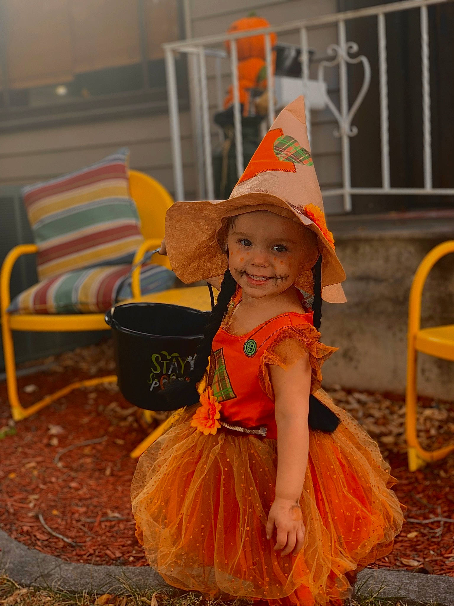 Harper is registered to the contest to win money with this photo: calabaza, child, costume, costume_hat, event, fun, happy, hat, headgear, headwear, joy, leisure, orange, party_supply, person, pumpkin, sitting, smile, sun_hat, toddler