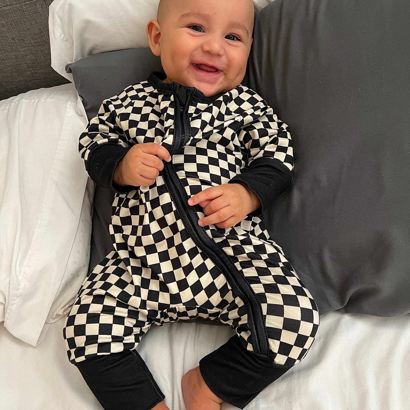Carter is registered to the contest to win money with this photo: baby, babylaughing, blanket, clothing, coat, couch, cushion, face, furniture, happy, head, homedecor, pajamas, pants, person, photography, portrait, shorts, sitting, smile