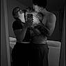 couple, dog, pet, mirror_selfie, black_and_white, bedroom, mirror, smartphone, shirtless, woman, man, hugging, kissing, portrait, indoor, bed, intimate, moody_lighting, reflection, casual
