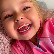 Aya participe au concours pour gagner de l'argent avec cette photo : child, smiling, laughing, face, teeth, pink_clothing, purple_clothing, blanket, closeup, happy, cute, person, young, indoor, portrait, head, skin, eyelashes, nose, mouth
