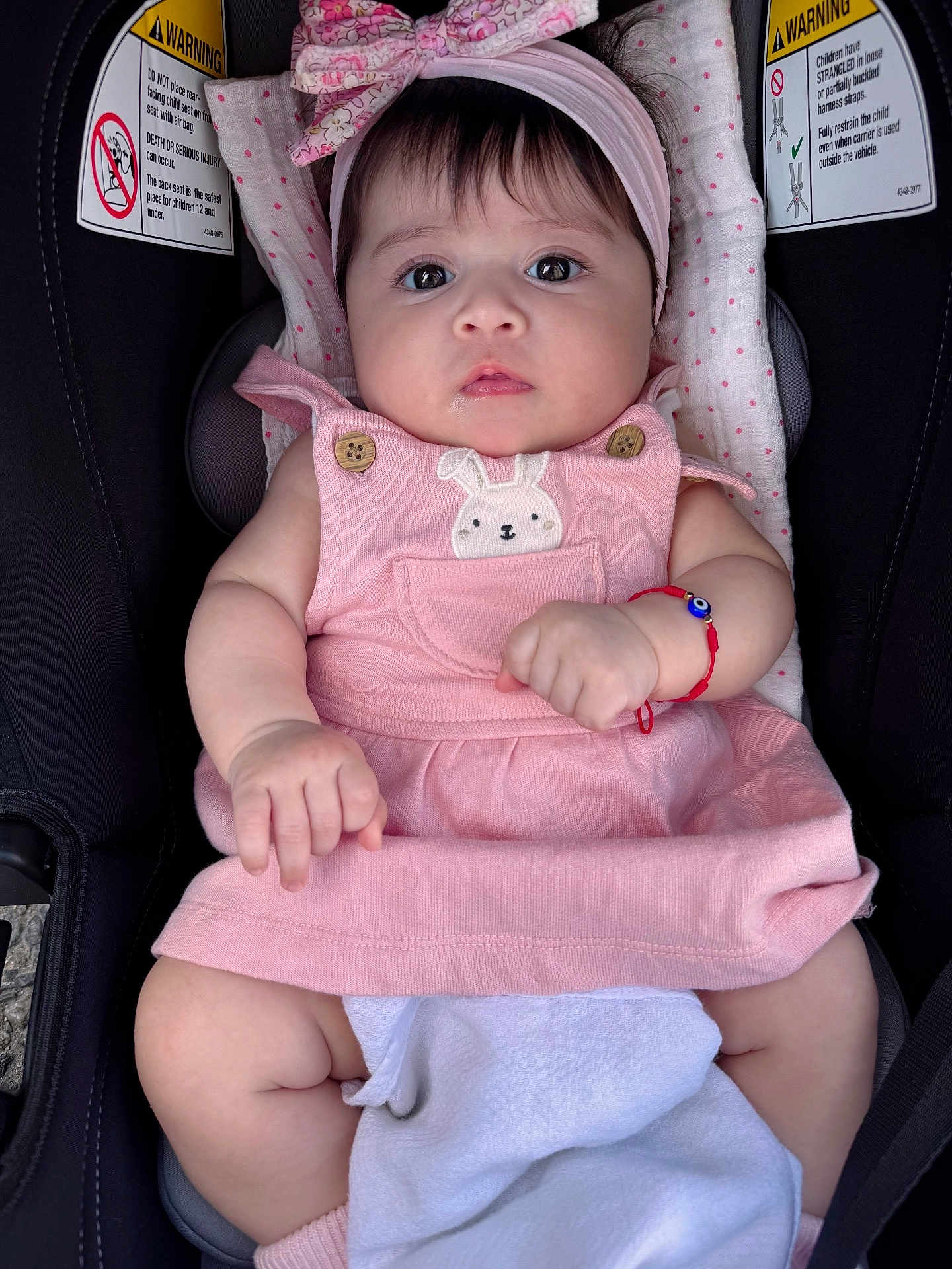 Elizabeth joined the competition — help win amazing prizes! baby, infant, pink_dress, headband, car_seat, warning_labels, blanket, bracelet, cute, child, portrait, indoor, clothing, person, seat, sitting, face, expression, young_child, adorable