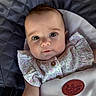 baby, infant, child, face, eyes, clothing, floral, seat, cushion, fabric, portrait, cute, expression, soft_lighting, ruffles, button, skin, head, comfort, indoor
