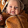 baby, infant, smiling, hoodie, fur_clothing, cute, child, face, blue_eyes, closeup, cozy, warm_clothing, soft_texture, indoors, portrait, happy, small_hand, baby_clothes, animal_ears, toddler