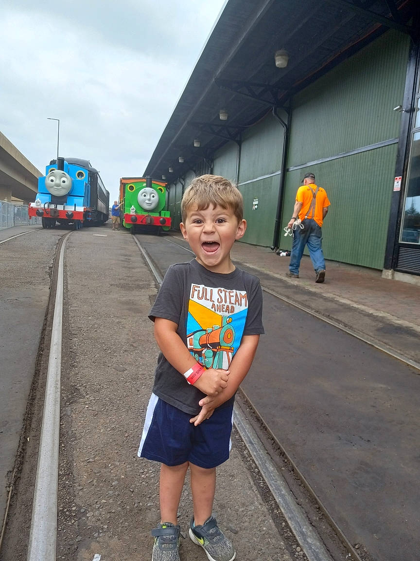 Finnley joined the competition — help win amazing prizes! anger, asphalt, child, electric_blue, fun, leisure, locomotive, passenger_car, pedestrian, person, railway, recreation, road, rolling, rolling_stock, shorts, sidewalk, sky, t_shirt, track