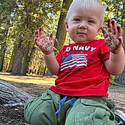 Hunter joined the competition — help win amazing prizes! toddler, child, dirt, hands, red_shirt, green_pants, kneeling, forest, trees, outdoor, daylight, play, messy, person, nature, young_child, casual_clothing, short_hair, ground, curious