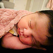 Camila Victoria is registered to the contest to win money with this photo: baby, newborn, sleeping, blanket, pink_blanket, infant, closed_eyes, cheek, arm, dark_hair, soft_texture, cozy, portrait, indoor, nursery, peaceful, skin, onesie, closeup, resting