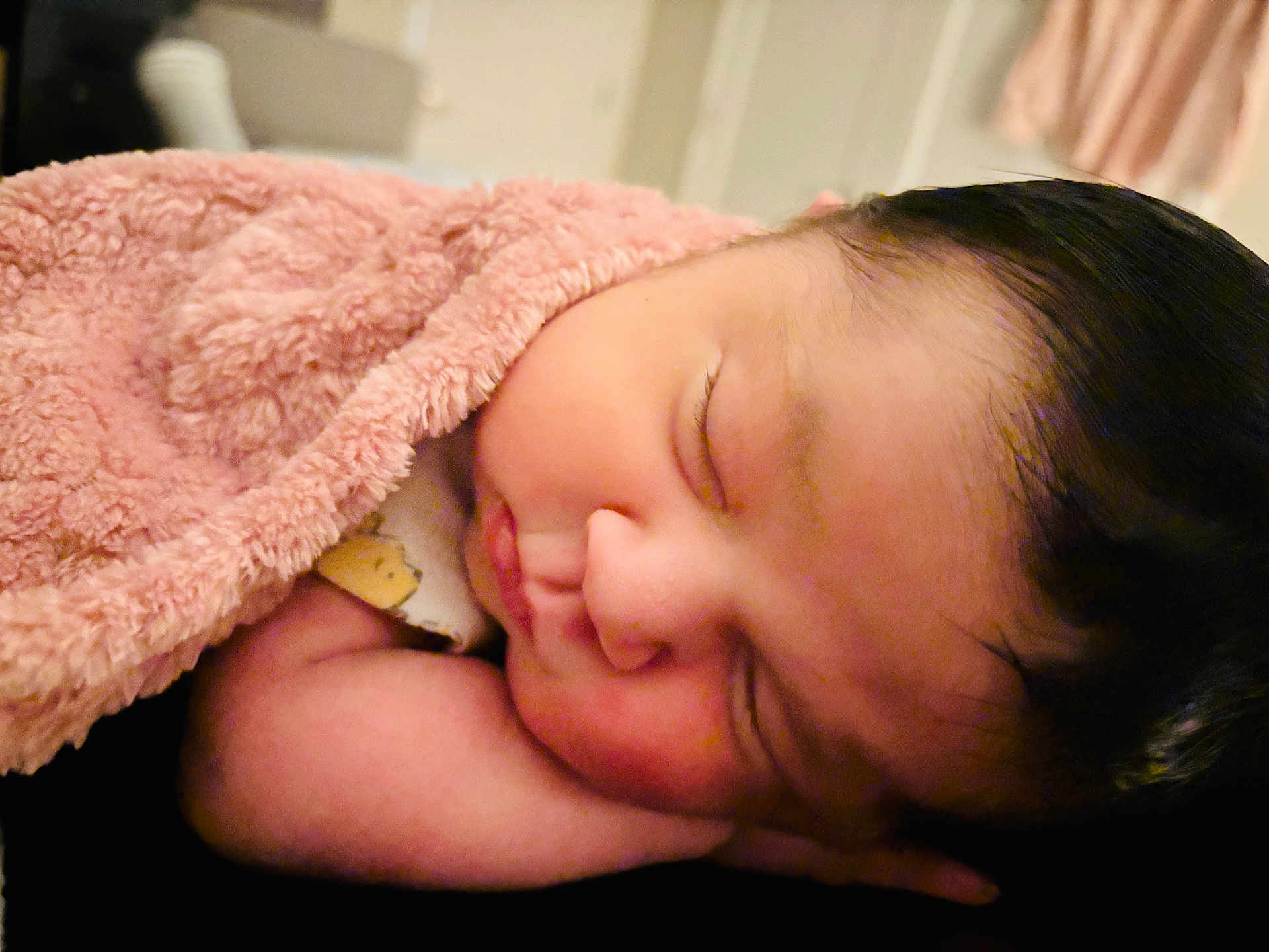 Camila Victoria is registered to the contest to win money with this photo: baby, newborn, sleeping, blanket, pink_blanket, infant, closed_eyes, cheek, arm, dark_hair, soft_texture, cozy, portrait, indoor, nursery, peaceful, skin, onesie, closeup, resting