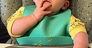 Khloe is registered to the contest to win money with this photo: baby, bib, child, crumbs, curious, cute, eating, face, feeding, fingers, food, high_chair, indoor, infant, mess, messy, sitting, table, tray, yellow_clothing