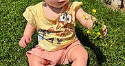Khloe joined the competition — help win amazing prizes! toddler, child, grass, yellow_flowers, outdoor, sunlight, barefoot, brick_wall, greenery, curious, shorts, yellow_shirt, holding, nature, summer, person, baby, plant, daylight, casual