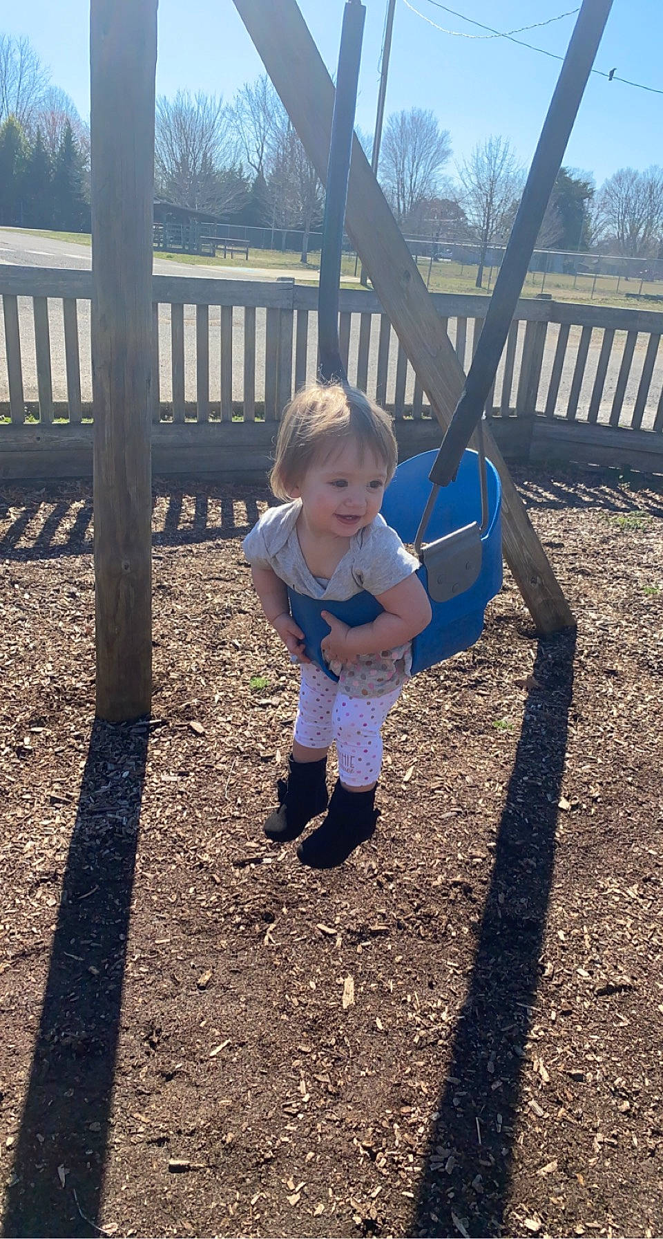 Mileiah joined the competition — help win amazing prizes! baby, baby_toddler_clothing, city, fence, fun, grass, leaf, leg, leisure, outdoor_play_equipment, people_in_nature, person, playground, public_space, recreation, shade, sky, swing, toddler, tree