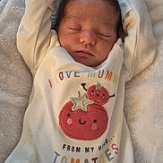 Cassian is registered to the contest to win money with this photo: newborn, baby, sleeping, blanket, onesie, clothing, face, infant, cute, cozy, couch, soft, indoors, child, peaceful, resting, smile, text, tomato, person