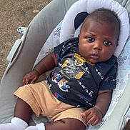 Legend joined the competition — help win amazing prizes! baby, infant, child, sitting, cushion, baby_seat, outdoor, concrete, shorts, tshirt, socks, dark_skin, cute, portrait, looking_at_camera, casual_clothing, relaxed, small_hands, footwear, young_child