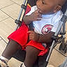 Legend joined the competition — help win amazing prizes! adult_leg, baby, baby_shoes, casual_clothing, child, curious, footwear, hand_on_face, indoor, jeans, person, red_shorts, seated, side_view, socks, spiderman_logo, stroller, tiled_floor, white_tshirt, young_child