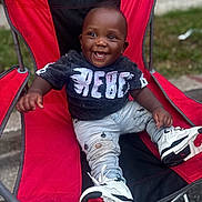 Legend joined the competition — help win amazing prizes! baby, black_shirt, casual, chair, child, clothing, cute, daylight, footwear, grass, happy, jeans, outdoor, person, portrait, red_chair, sitting, smiling, sneakers, toddler