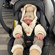 Delilah joined the competition — help win amazing prizes! baby, car_seat, winter_clothing, beanie, sleeping, infant, cozy, warm, socks, straps, indoor, flooring, jacket, child, cute, toddler, headwear, hands, padded, comfort