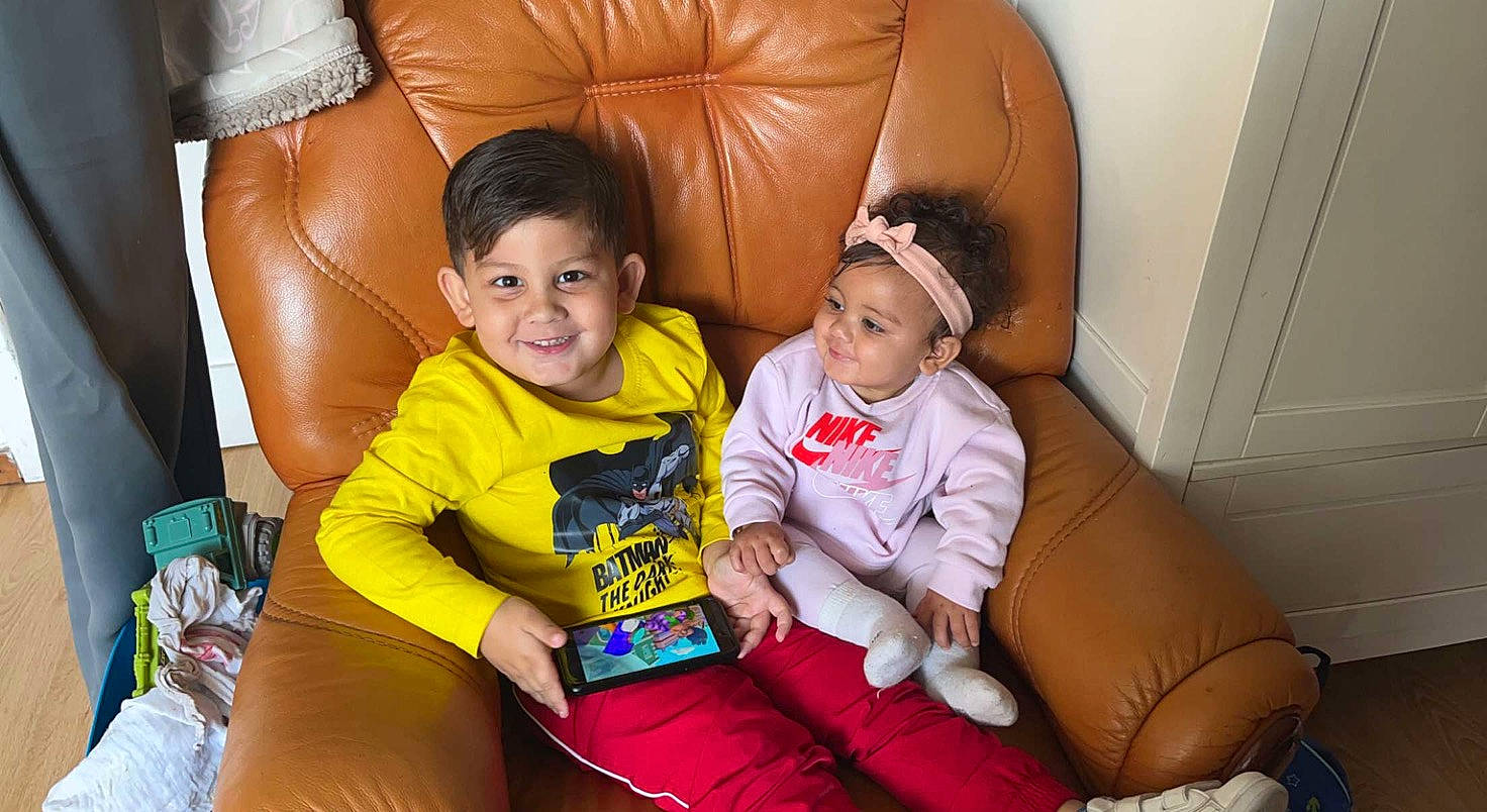 Kélya participe au concours pour gagner de l'argent avec cette photo : baby_toddler_clothing, child, comfort, couch, event, finger, flooring, fun, happy, head, headwear, human_body, joy, lap, leisure, living_room, person, sitting, skin, smile