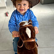 Mylan a rejoint le concours — aidez-le/la à gagner de superbes lots ! child, toddler, cowboy_hat, blue_shirt, rocking_horse, indoor, toy, smiling, curly_hair, happy, playtime, wooden_floor, plush_toy, cute, portrait, fun, person, childhood, home, bright