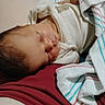 Sophie is registered to the contest to win money with this photo: newborn, baby, sleeping, infant, face, portrait, indoors, blanket, towel, clothing, red_cushion, lying_down, resting, peaceful, closed_eyes, hair, home, cozy, photography, child