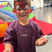 Cole joined the competition — help win amazing prizes! child, smiling, face_paint, spider, portrait, indoor, birthday_party, balloons, inflatables, play_area, purple_shirt, short_hair, standing, hands, fun, colorful, chairs, floor, happy, photography