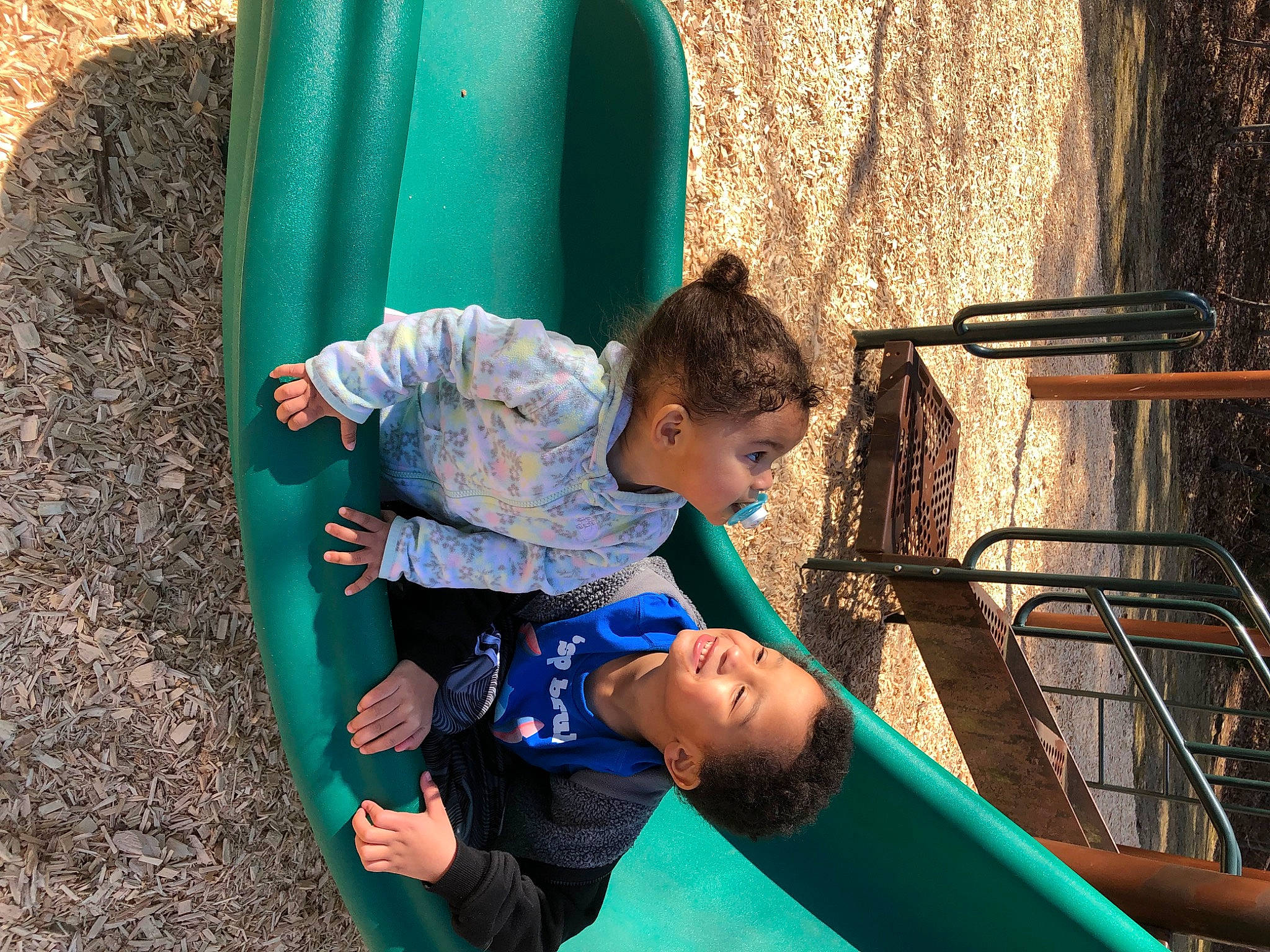 Melodi is registered to the contest to win money with this photo: blue, child, chute, city, electric_blue, fun, grass, green, happy, leisure, outdoor_play_equipment, person, play, playground, playground_slide, recreation, sitting, summer, t_shirt, toddler