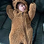 Bentley is registered to the contest to win money with this photo: baby, infant, onesie, bear_costume, fuzzy, cute, couch, leather, child, clothing, zipper, hood, ears, indoor, young, small, person, lying_down, warm, soft