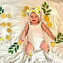 adorable, baby, child, closeup, cute, decorative, fresh, green_leaves, happy, headband, infant, lemon_slices, lying_down, natural_light, portrait, smiling, socks, summer_theme, white_outfit, white_sheet