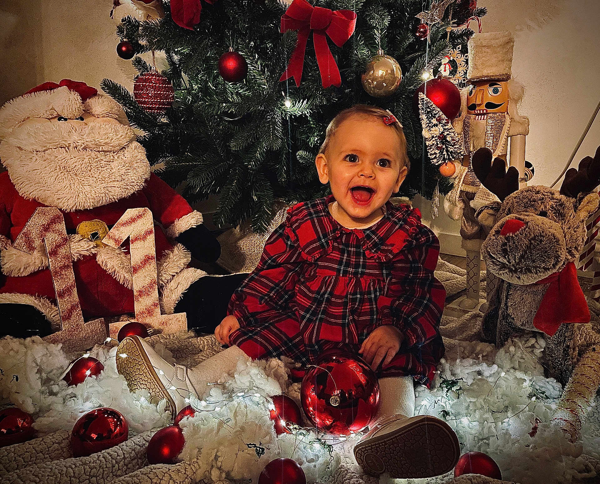 Eden a rejoint le concours — aidez-le/la à gagner de superbes lots ! toddler, child, christmas_tree, christmas_decorations, santa_plush, nutcracker, reindeer, red_dress, holiday_lights, ornaments, festive, smiling, indoors, holiday_season, christmas_balls, plush_toys, celebration, happy, festive_clothing, seasonal
