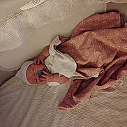 Phoenix is registered to the contest to win money with this photo: baby, bed, blanket, bodypart, bonnet, clothing, couch, cradle, crib, face, finger, furniture, hand, hat, head, homedecor, infantbed, linen, newborn, person