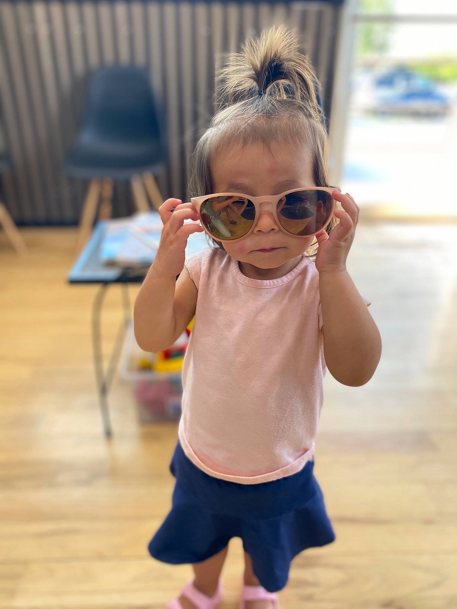 Blair is registered to the contest to win money with this photo: cool, eyewear, facial_expression, flooring, glasses, goggles, happy, leisure, neck, person, shorts, skin, sleeve, sportswear, street_fashion, sunglasses, thigh, toddler, vision_care, waist