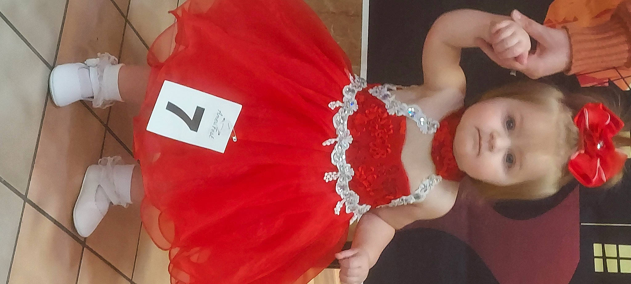 Riverlynn is registered to the contest to win money with this photo: baby, baby_products, baby_toddler_clothing, carmine, chest, child, event, eyelash, fashion_accessory, gesture, hair_accessory, happy, headpiece, jewellery, magenta, nail, pattern, person, room, toddler