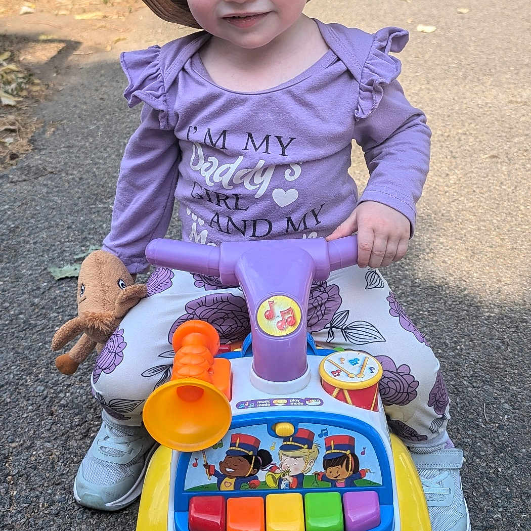 Lily joined the competition — help win amazing prizes! baby, cap, clothing, face, footwear, grass, hat, head, nature, outdoors, park, person, photography, plant, playarea, portrait, shoe, sitting, summer, sunhat