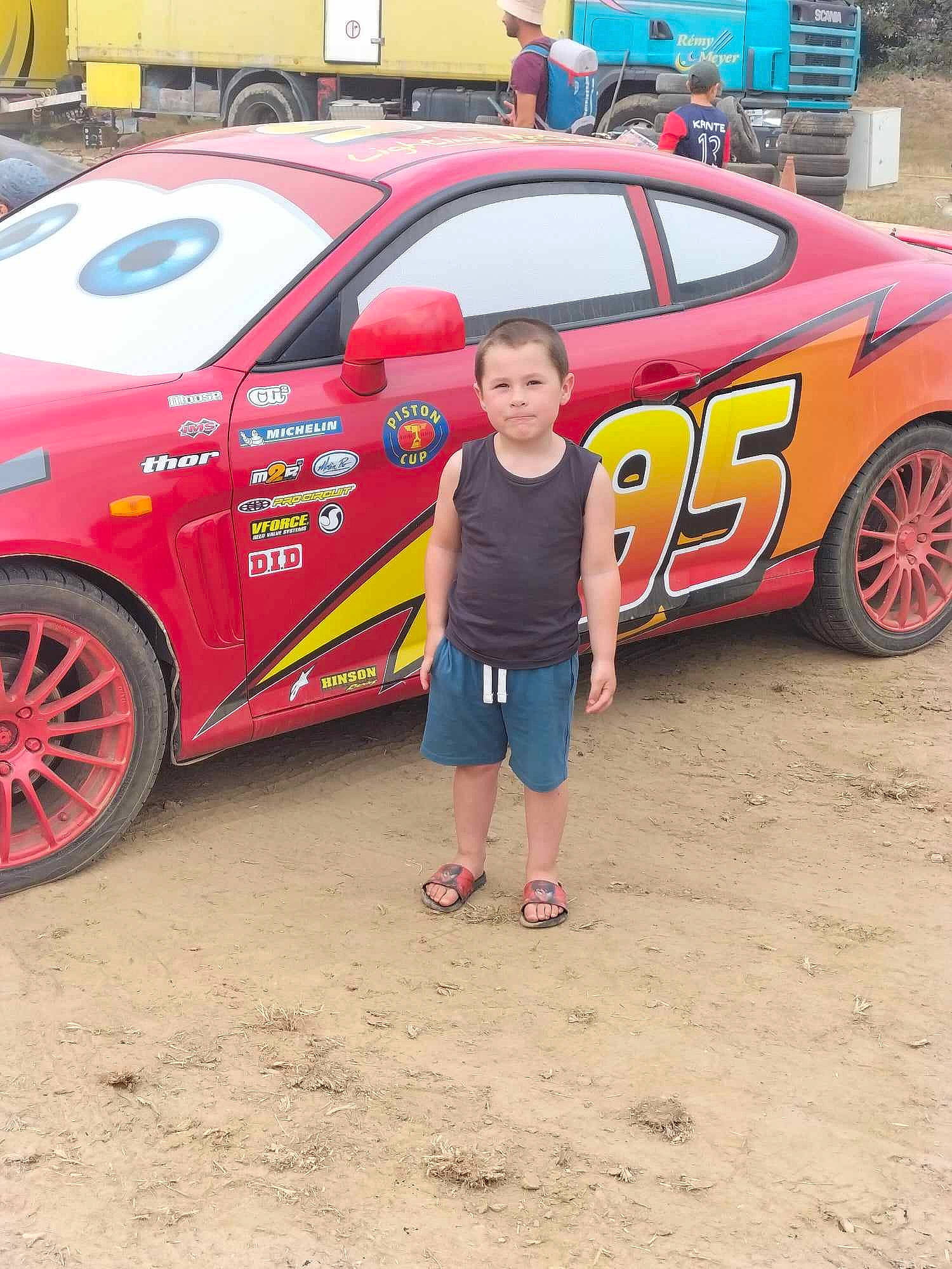 Lukas a rejoint le concours — aidez-le/la à gagner de superbes lots ! alloy_wheel, automotive_design, automotive_exterior, automotive_tire, automotive_wheel_system, bumper, car, hood, joy, land_vehicle, motor_vehicle, motorsport, person, personal_luxury_car, rim, shorts, tire, vehicle, vehicle_door, wheel