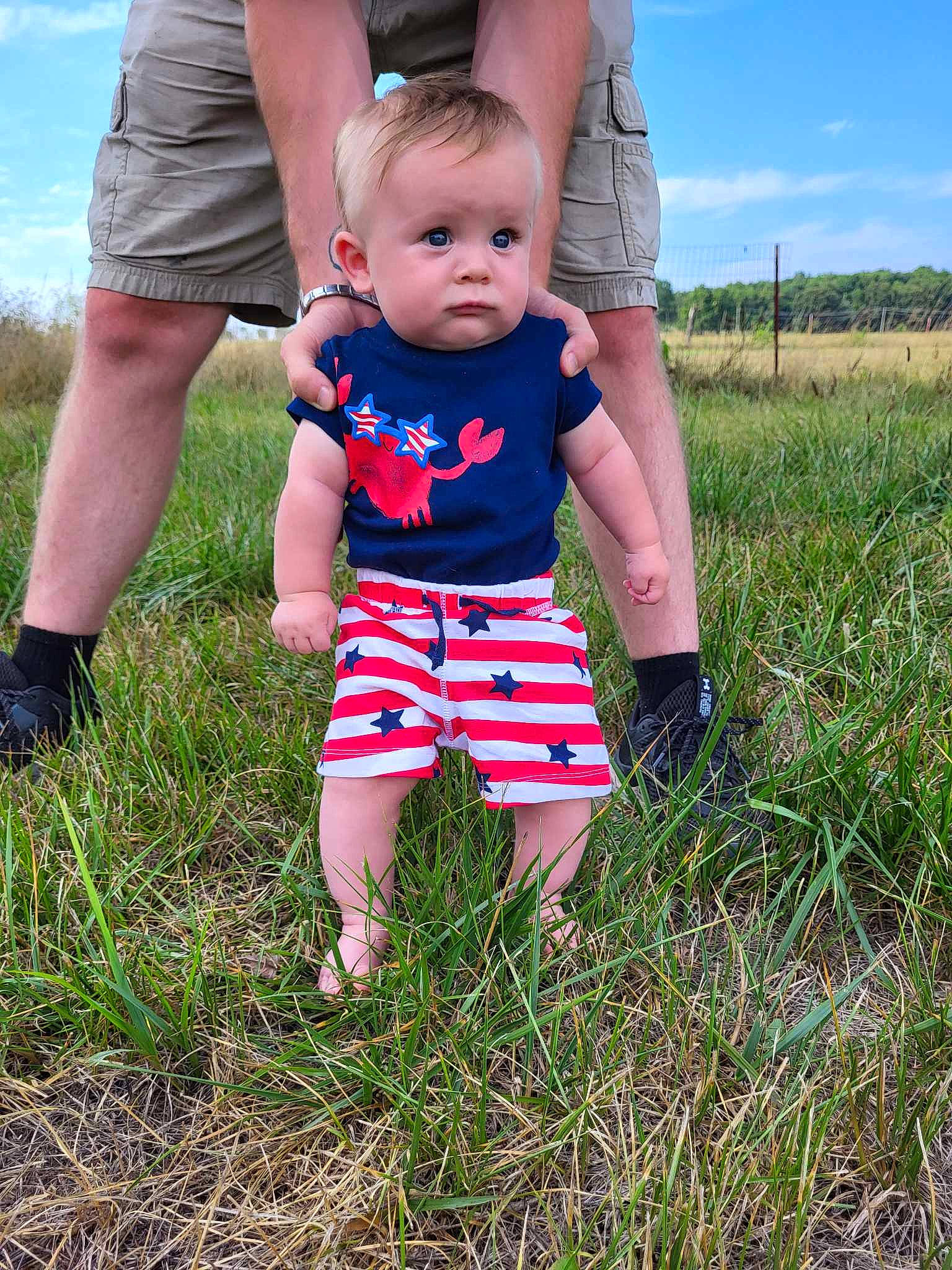 Nikolas joined the competition — help win amazing prizes! baby_toddler_clothing, child, cloud, electric_blue, fun, gesture, grass, grassland, happy, meadow, pattern, people_in_nature, person, plant, prairie, shorts, sky, summer, t_shirt, toddler
