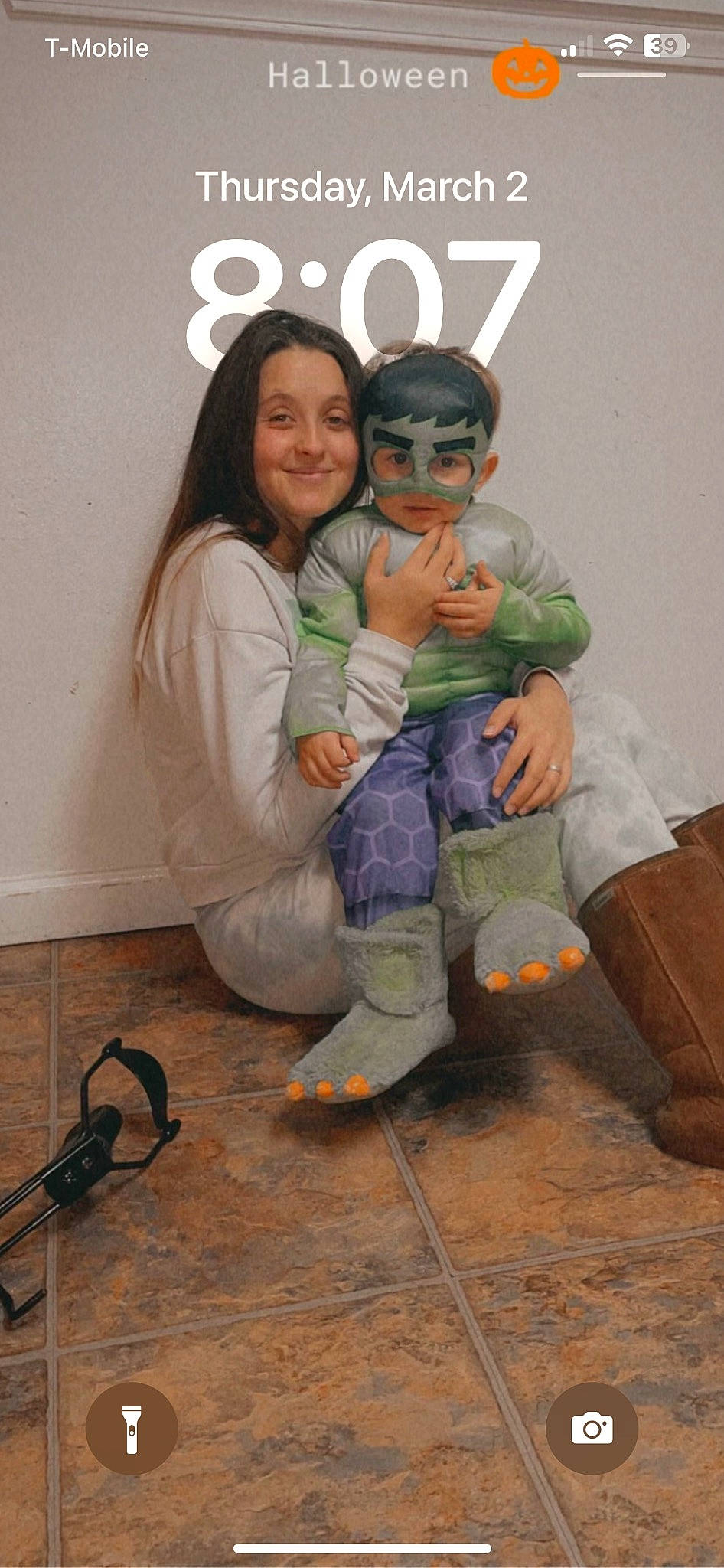 Ayden is registered to the contest to win money with this photo: boot, child, costume, event, eye, flooring, fun, gesture, glove, happy, hoodie, joy, leg, person, personal_protective_equipment, room, sandal, sitting, sleeve, smile