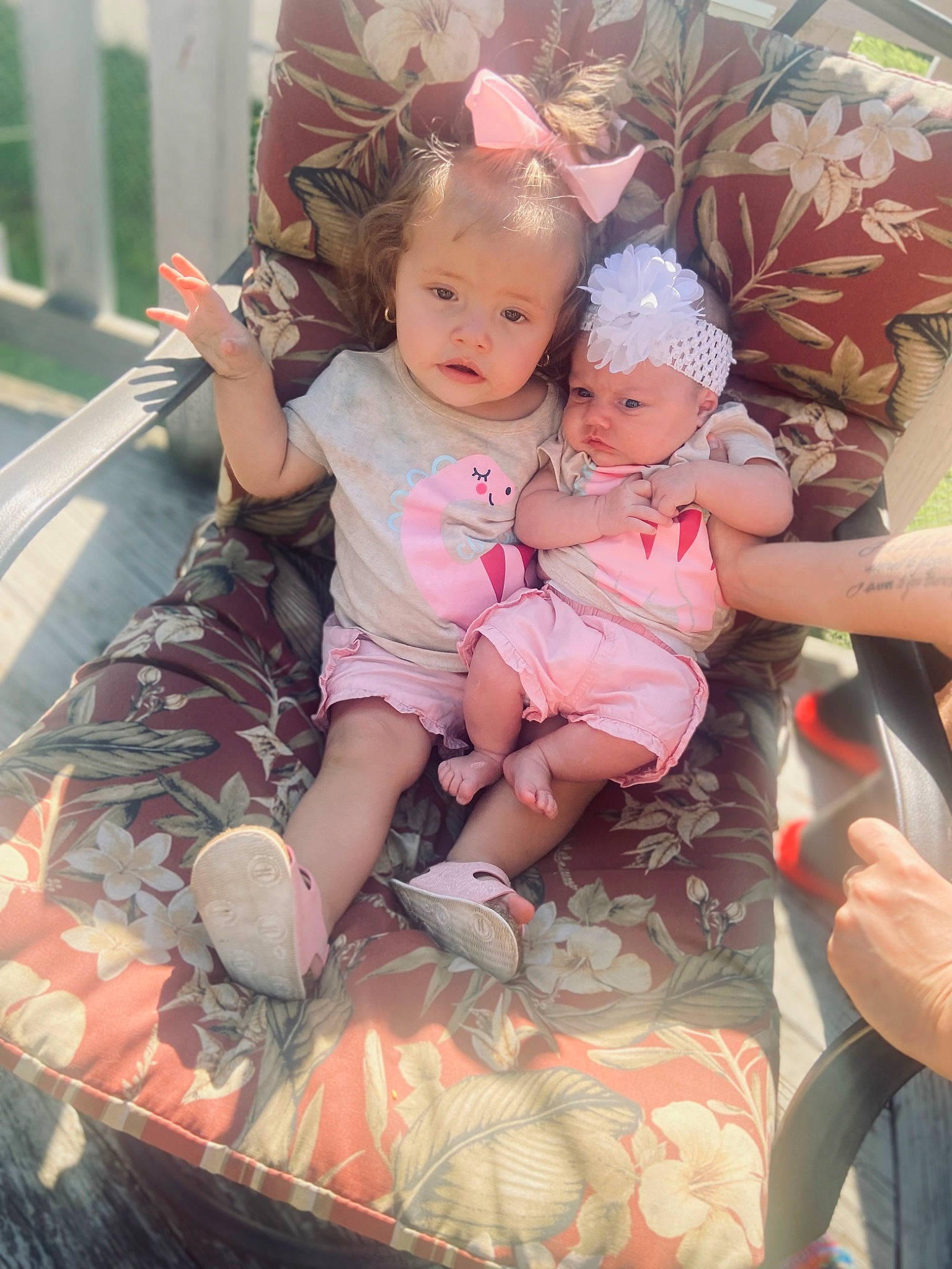 Carmella is registered to the contest to win money with this photo: baby, baby_toddler_clothing, child, dress, event, eye, fun, grass, happy, headwear, human_body, lap, leg, mammal, person, pink, shorts, sitting, skin, textile