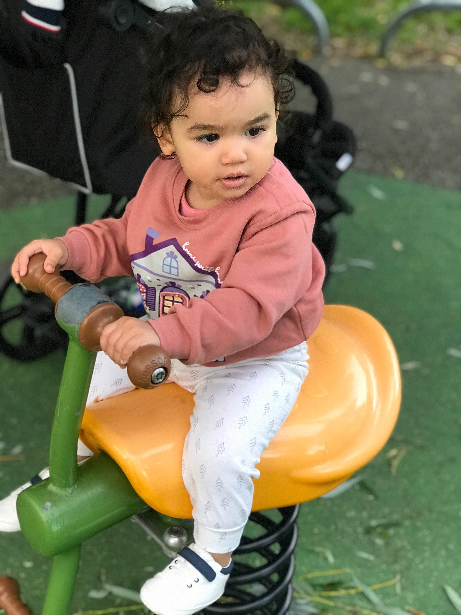 Jana a rejoint le concours — aidez-le/la à gagner de superbes lots ! baby, baby_toddler_clothing, chair, child, event, fun, grass, happy, lap, leisure, outdoor_play_equipment, person, play, playground, public_space, recreation, riding_toy, shorts, sitting, sneakers