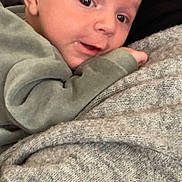 Liam participe au concours pour gagner de l'argent avec cette photo : baby, cheek, closeup, cozy, cuddle, expression, eyes, face, gaze, hand, holding, indoors, infant, mouth, newborn, person, portrait, skin, sleeve, sweater