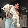 Apollo is registered to the contest to win money with this photo: athletic_wear, cat, cuddly, fur, holding, indoor, leggings, living_room, long_hair, pet, playful, relaxed, second_cat, smiling, sofa, tail, tattoo, watch, white_cat, woman